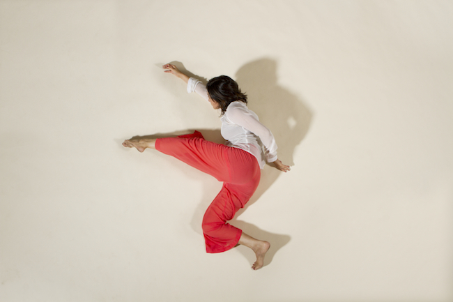 Jessica Chen in Red Pants looking like she's climbing up a wall